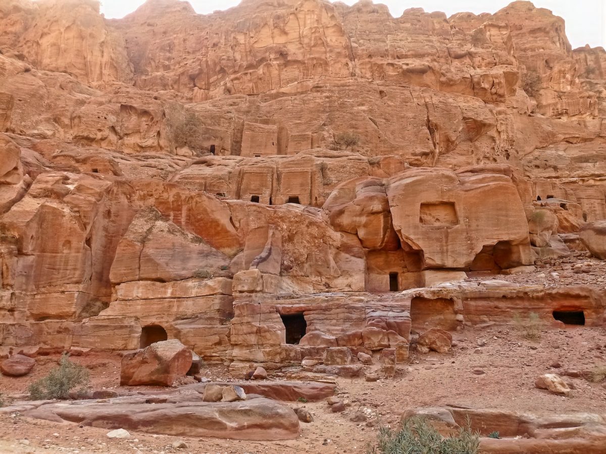 a group of people standing in front of a rock formation