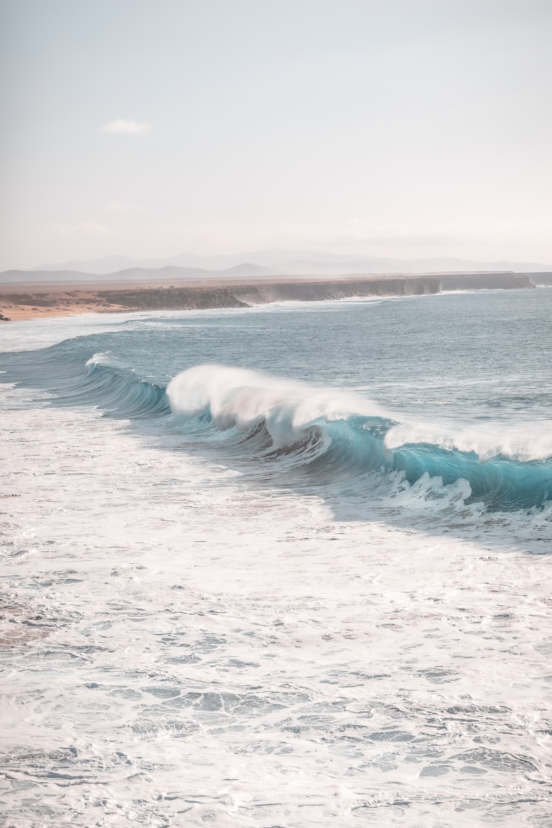ocean waves crashing on shore during daytime