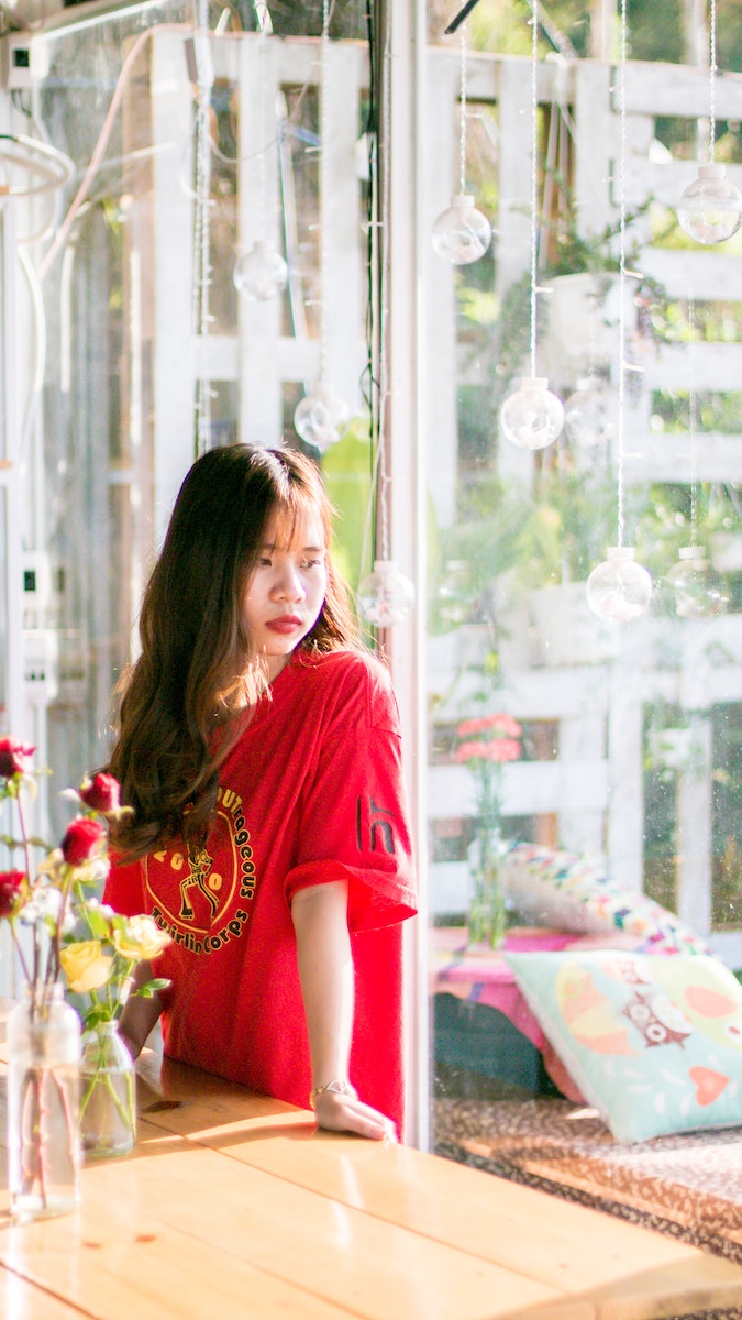 Woman Wearing Red Shirt Standing Near Table