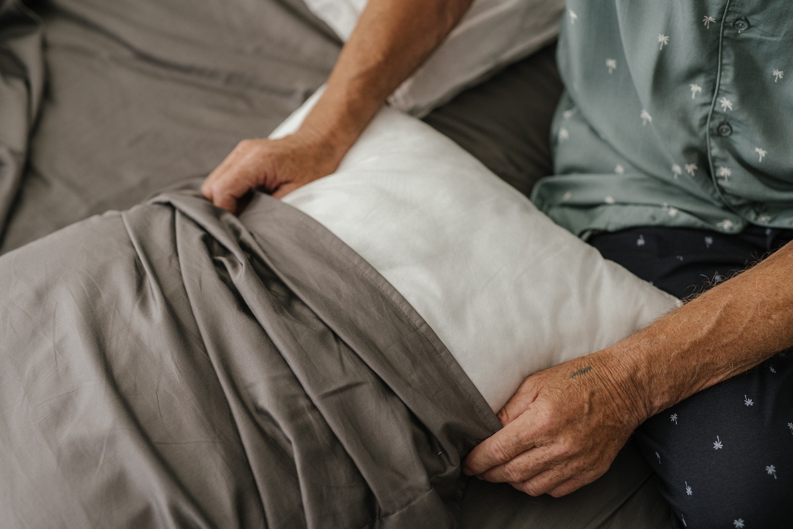 A Man Putting a Pillowcase on a Pillow