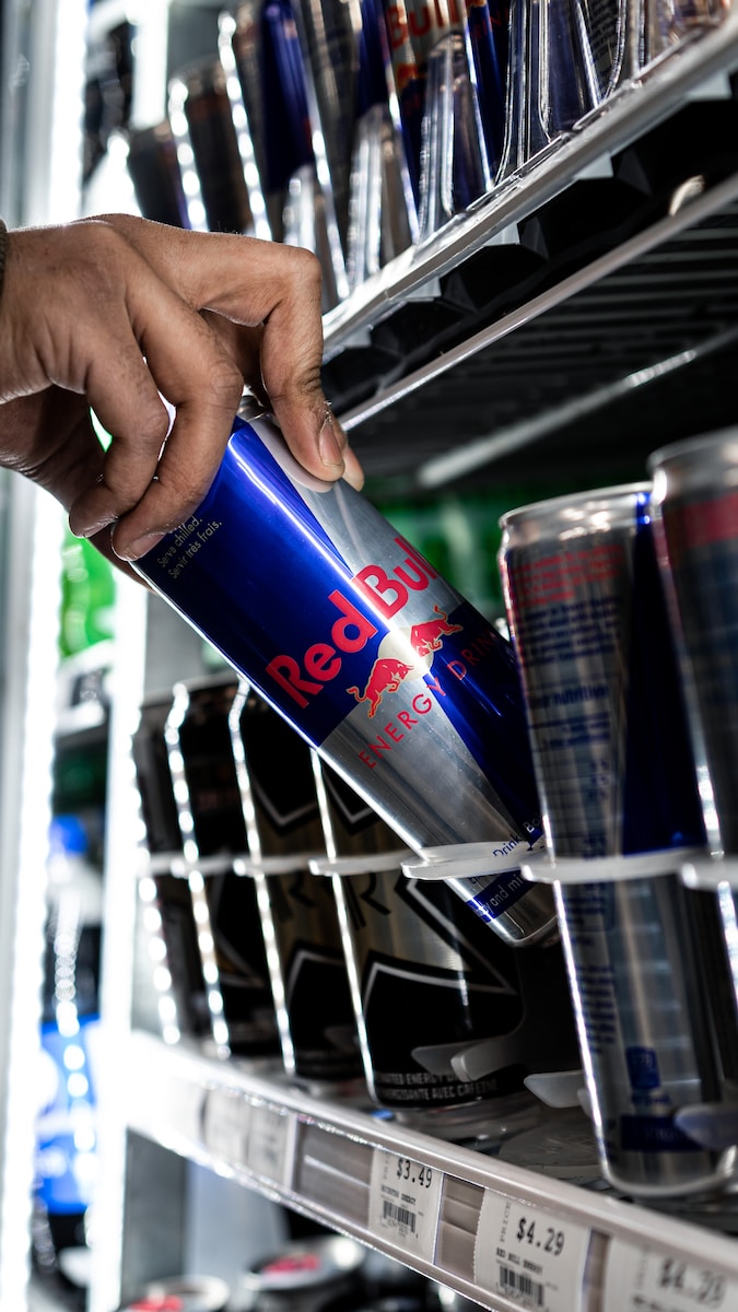 person holding red bull energy drink can
