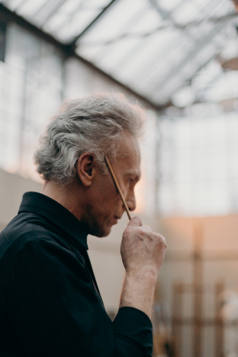 Side View Photo of Elderly Man Holding a Paint Brush