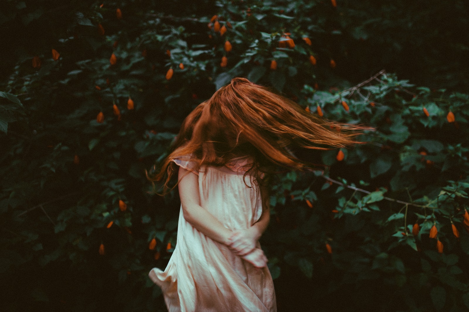 Girl in White Dress Standing in Front of Green Plants