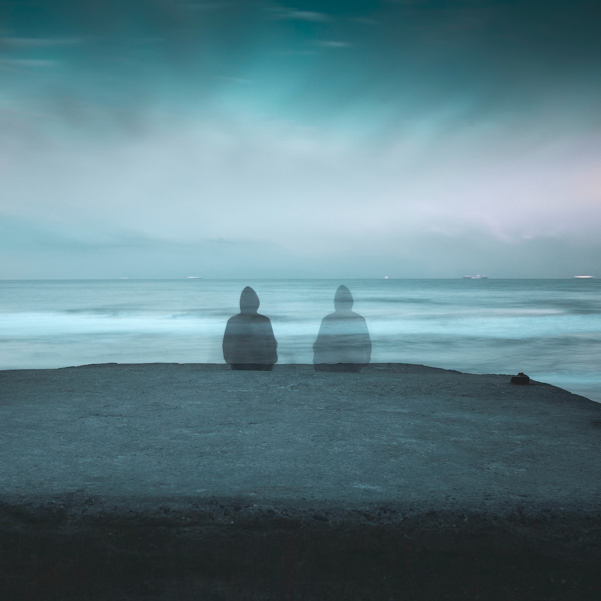 3 white and gray stone on black sand near body of water during daytime