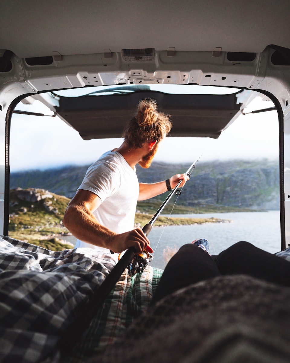 Man with a Beard Fishing out of a Camping Van