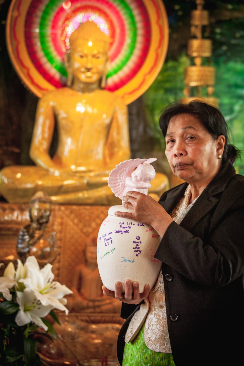 a person holding a vase with a statue of a person