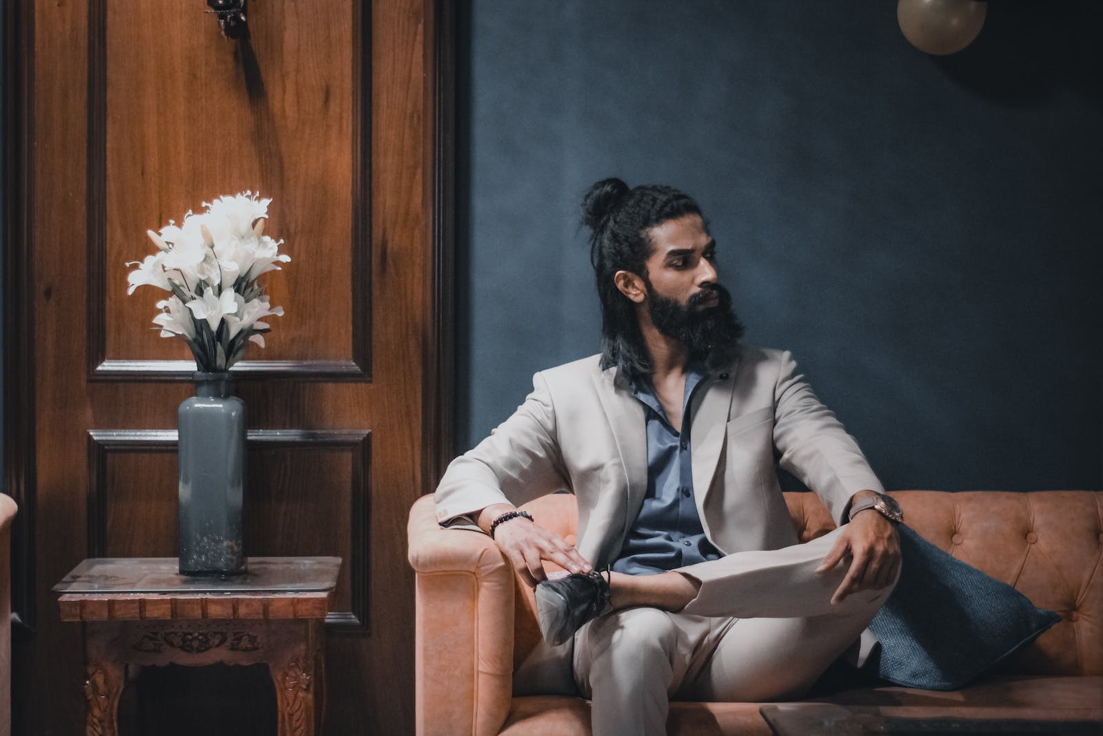 A Bearded Well-Dressed Man Sitting on the Sofa
