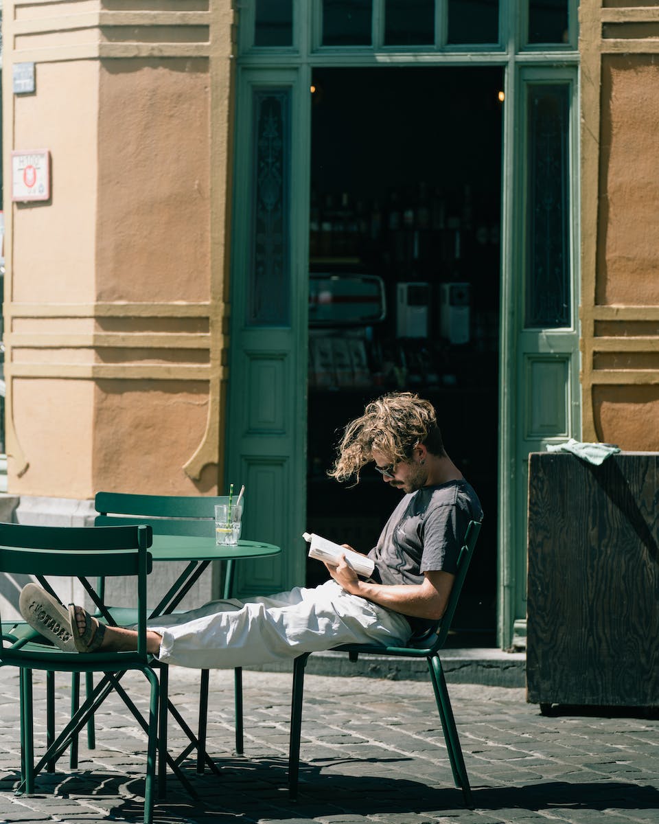 Man Sitting on Chairs and Reading