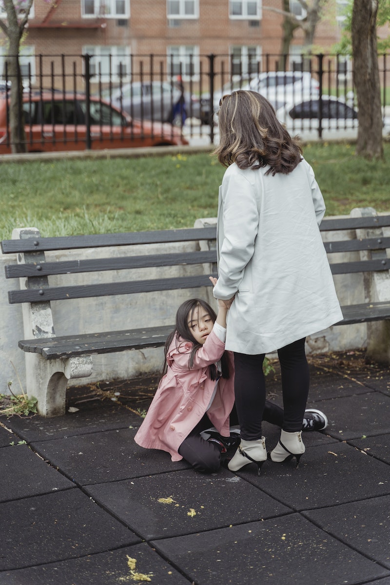 A Woman Holding a Young Girl while Sitting on the Ground