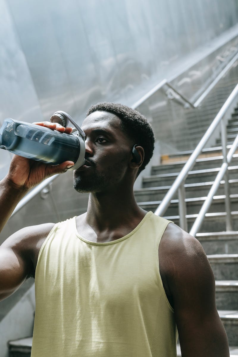 Man in Tank Top Drinking Water