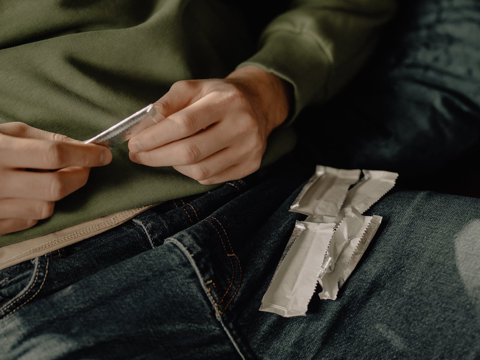 Person in Blue Denim Jeans Holding White Plastic Pack