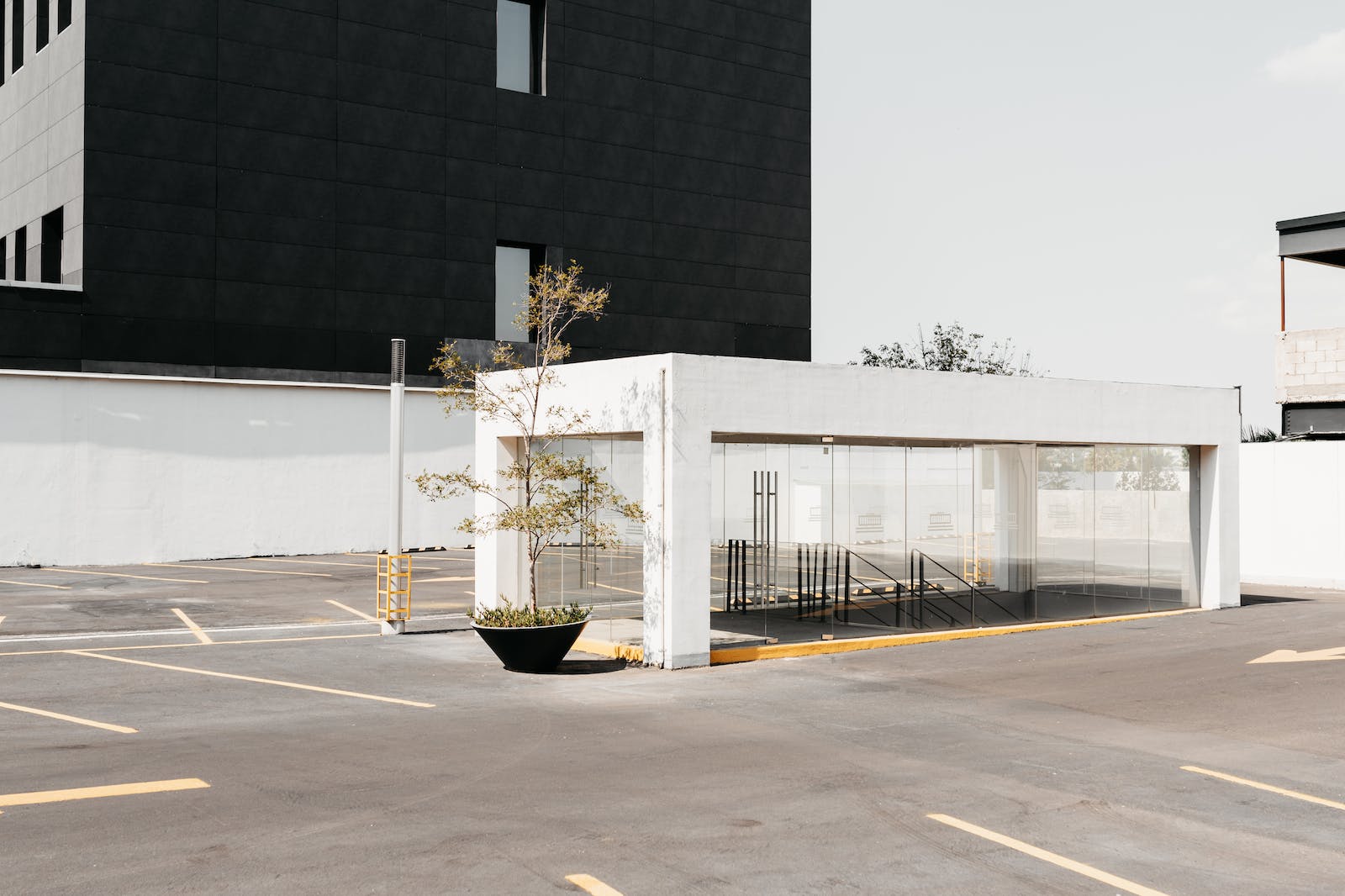 Empty parking with entrance to underpass near modern residential building in sunny day