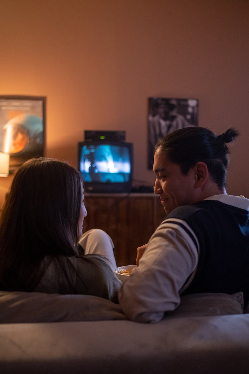 Man and woman watching tv on the couch