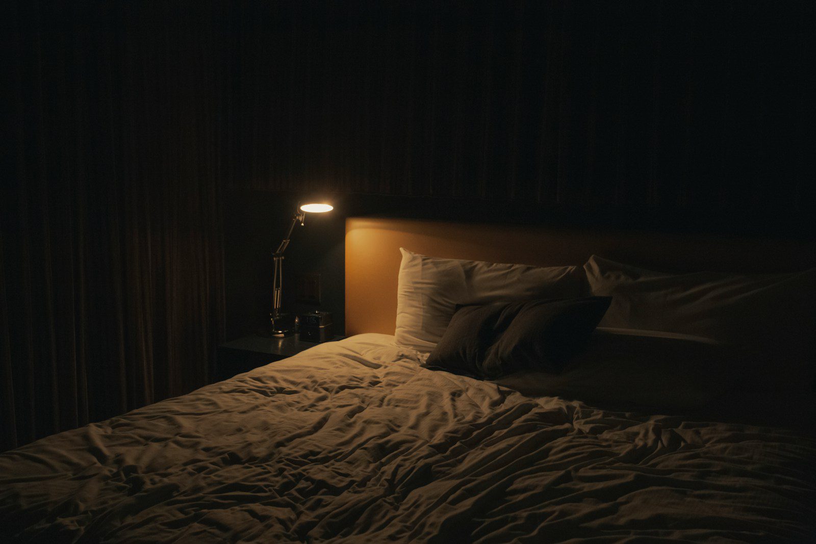 table lamp turned-on near bed