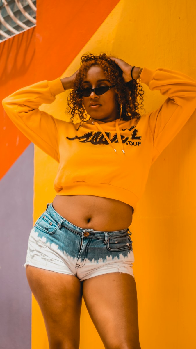 woman in yellow long sleeve shirt and blue denim shorts
