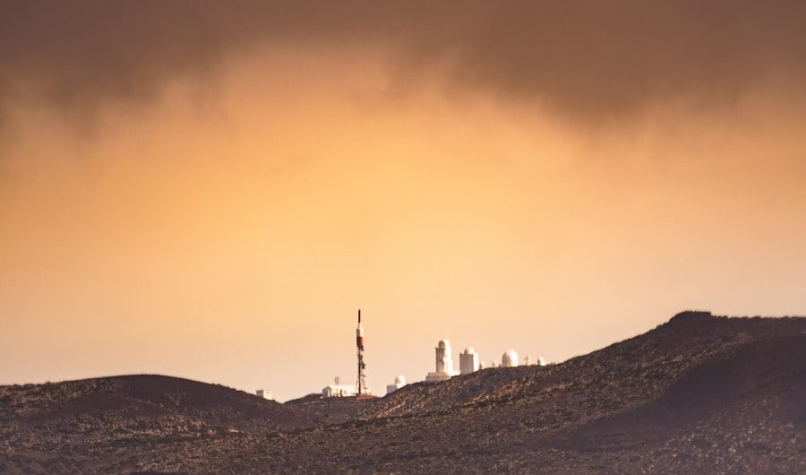 silhouette of person standing on rock formation during sunset