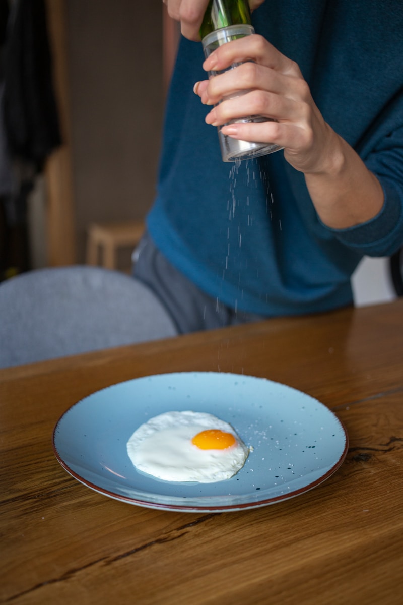 person in blue long sleeve shirt holding silver steel fork