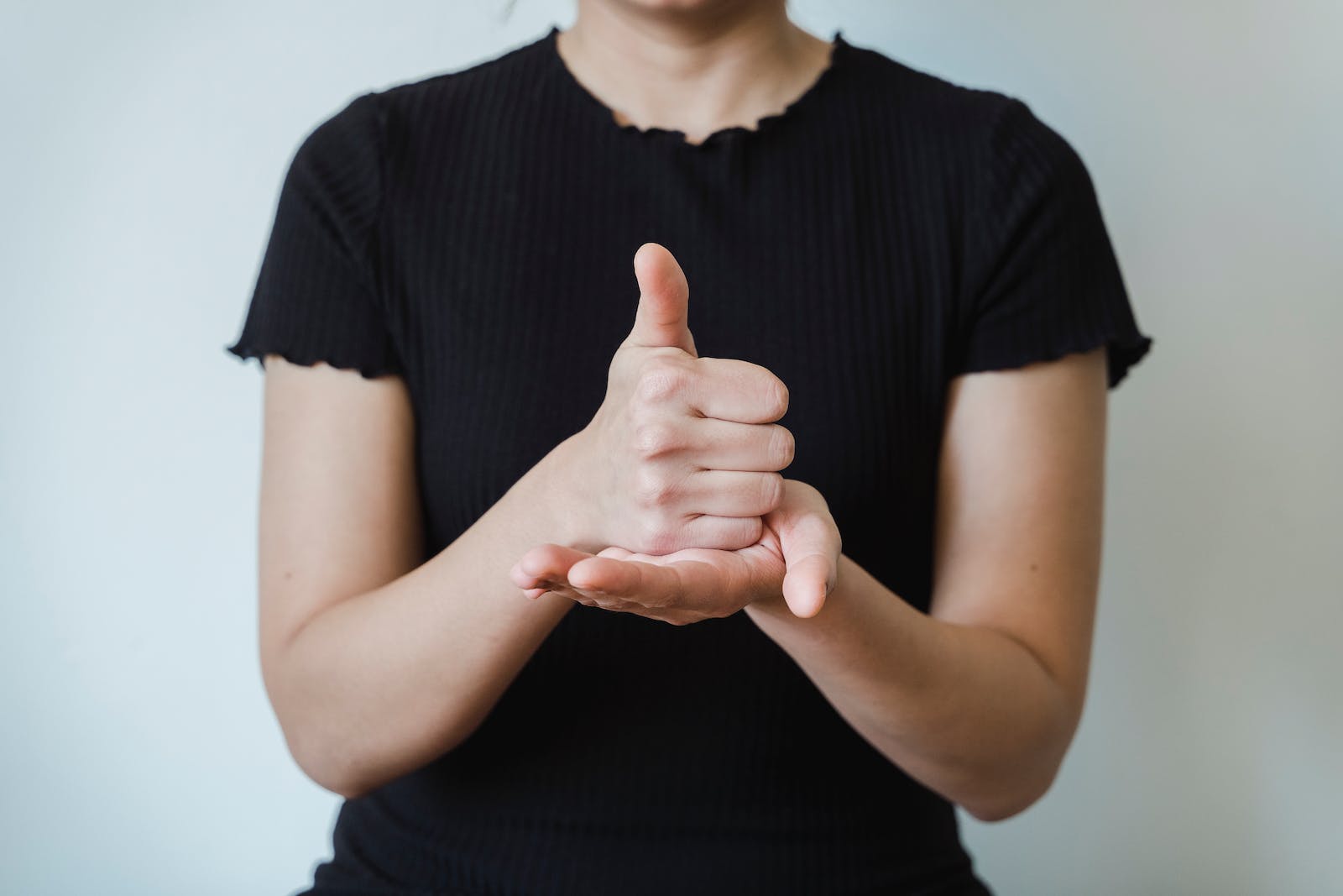 Hands of a Woman Making Hand Gesture of Thumbs Up