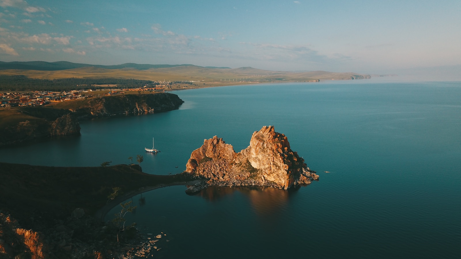 brown rock formation on blue sea under blue sky during daytime
