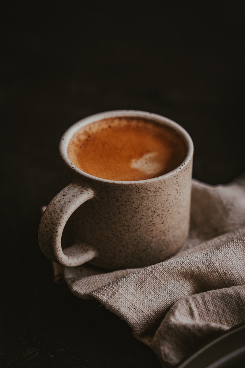 a cup of coffee sitting on top of a cloth