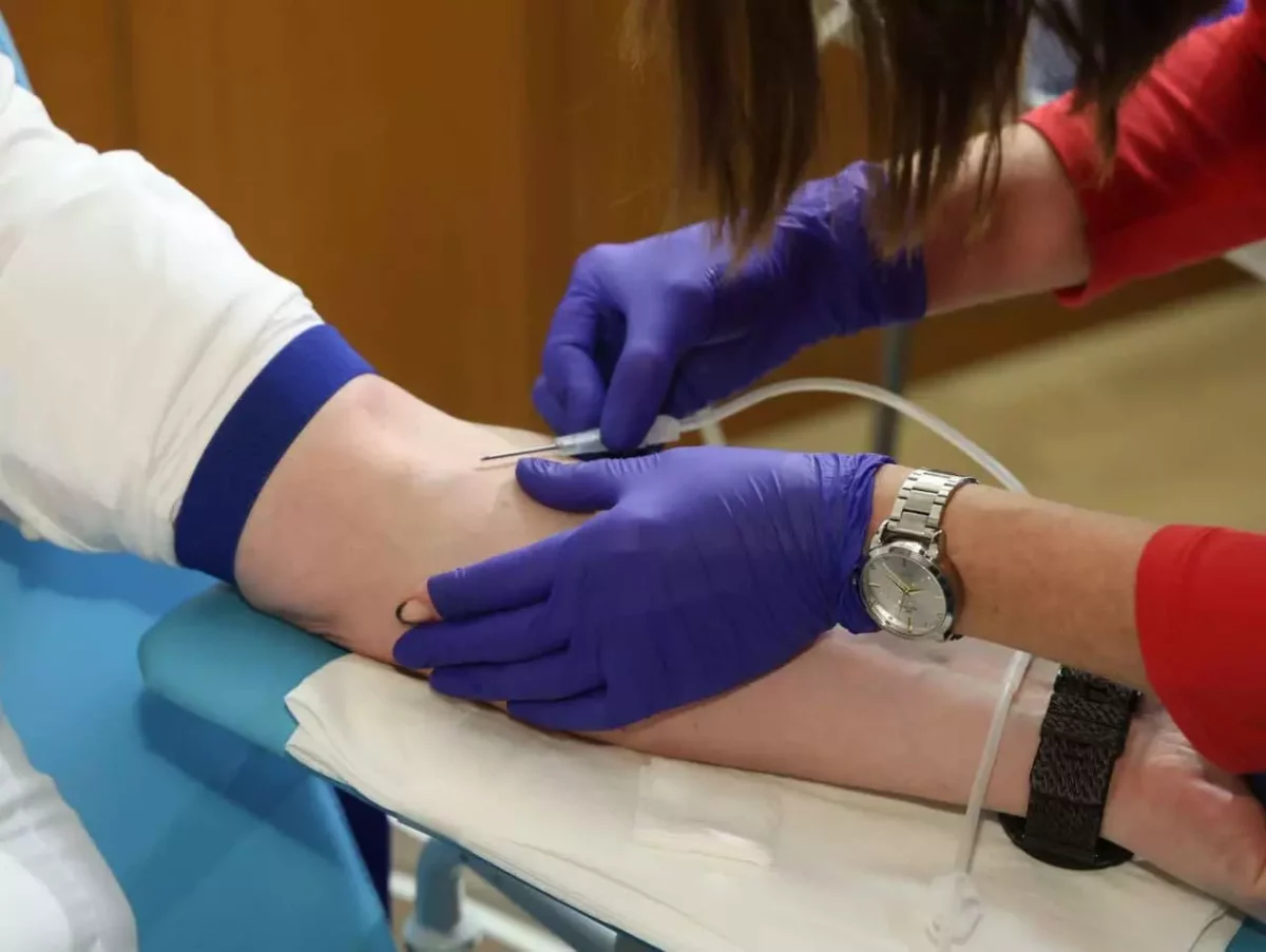 Odobratie krvi s modrou škrtidlom a fialovými rukavicami na klinike alebo v zdravotnom centre.