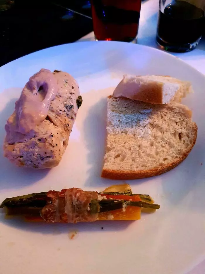 Tanier s porciou mäsa, kúskom chleba a zeleninou, servírované na bielej miske.