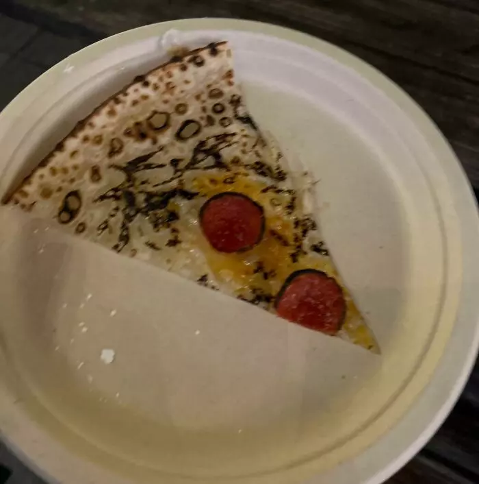 Kúsok pizze s paprikou a syrom v papierovej krabičke, pohľad zhora.