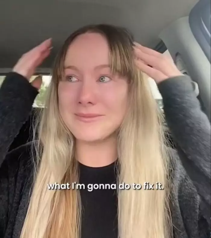 Žena v aute s dlhými vlasmi, vyzerá emocionálne rozrušená a drží si hlavu v rukách. Text: what I'm gonna do to fix it.