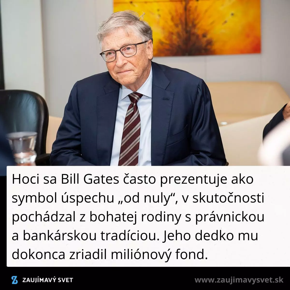 Muž v obleku sedí pri stole na obchodnom stretnutí, v pozadí je moderný obraz na stene.