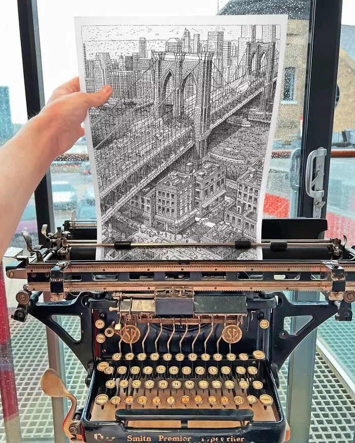 Stará písacia mašina drží kresbu brooklynského mosta na pozadí mestského panorámatu za sklenenými dverami.