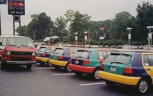 Rôznofarebné Volkswagen autá zaparkované vedľa seba na parkovisku pri autodelerovej spoločnosti.