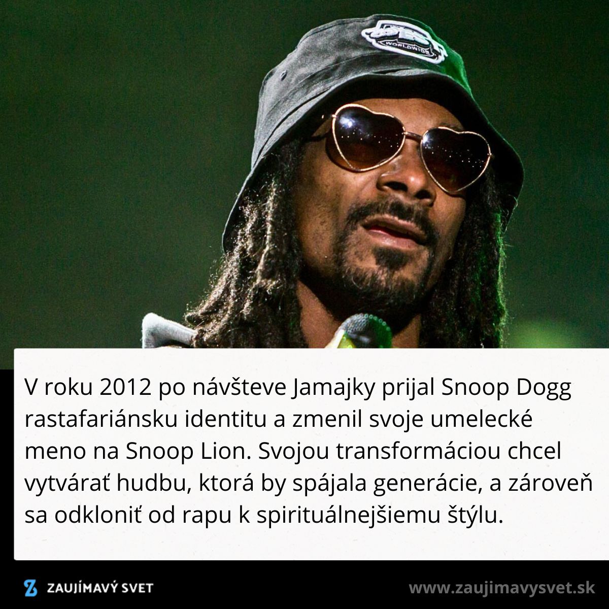 Hudobník s klobúkom a slnečnými okuliarmi na pódiu.
