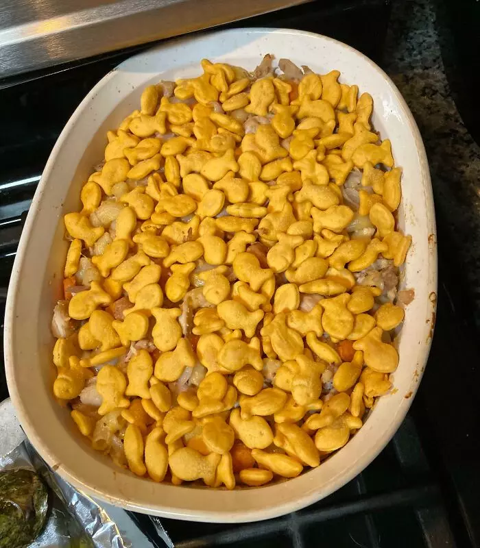 Zapečené jedlo s chrumkavými keksíkmi v tvare rybičiek v bielej keramickej mise.