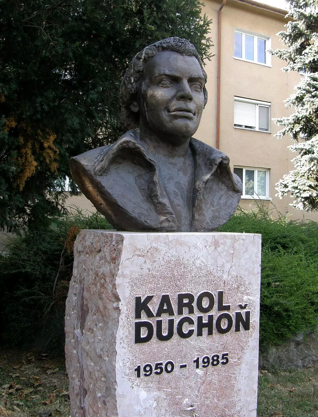 Busta Karola Duchoňa v parku, na podstavci meno a roky narodenia a úmrtia: 1950 - 1985.