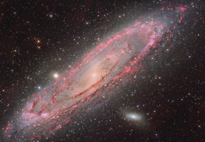 Špirálová galaxia Andromeda obklopená hviezdami a kozmickým prachom v úchvatnej snímke vesmíru.