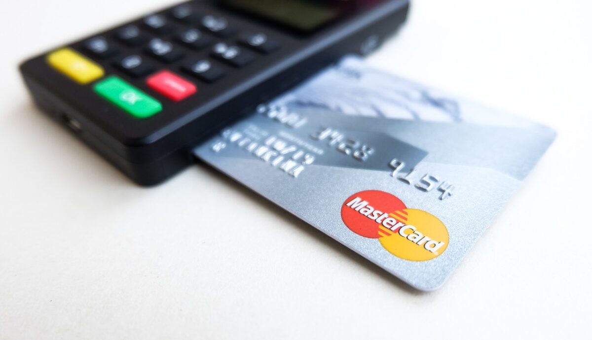 Platobný terminál s kreditnou kartou, logo Mastercard, bezkontaktná platba kartou v obchode.