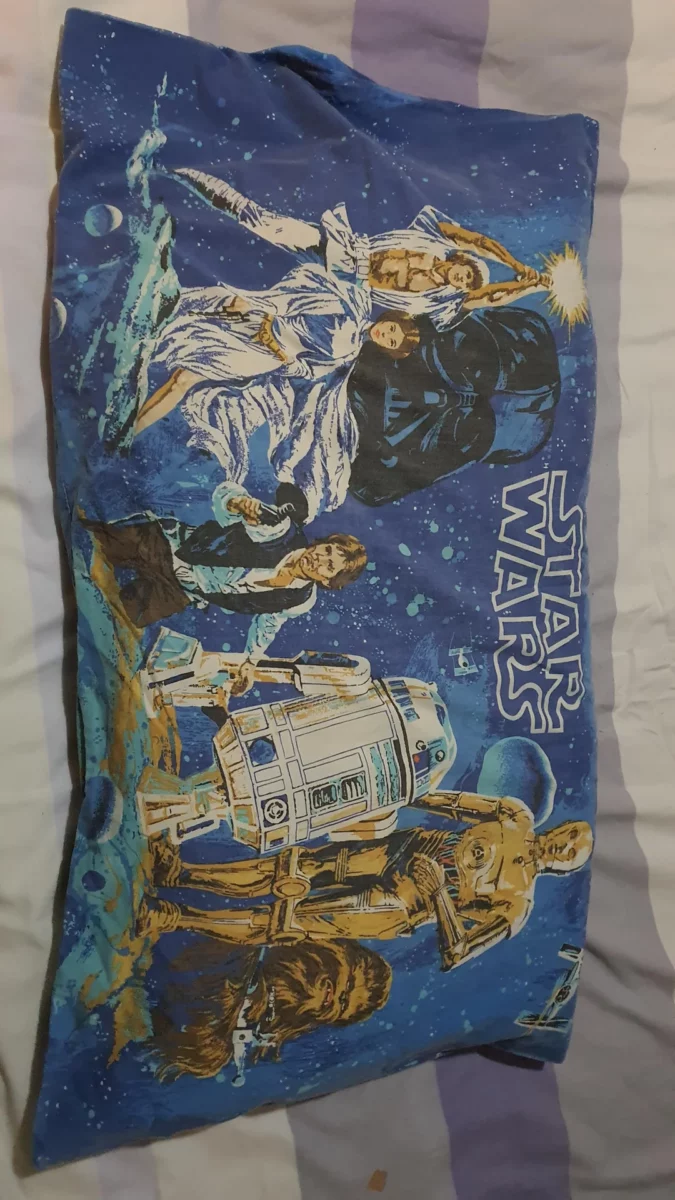 Star Wars obliečka s ikonickými postavami na modrom vesmírnom pozadí, zahŕňa robotov a bojovníkov.
