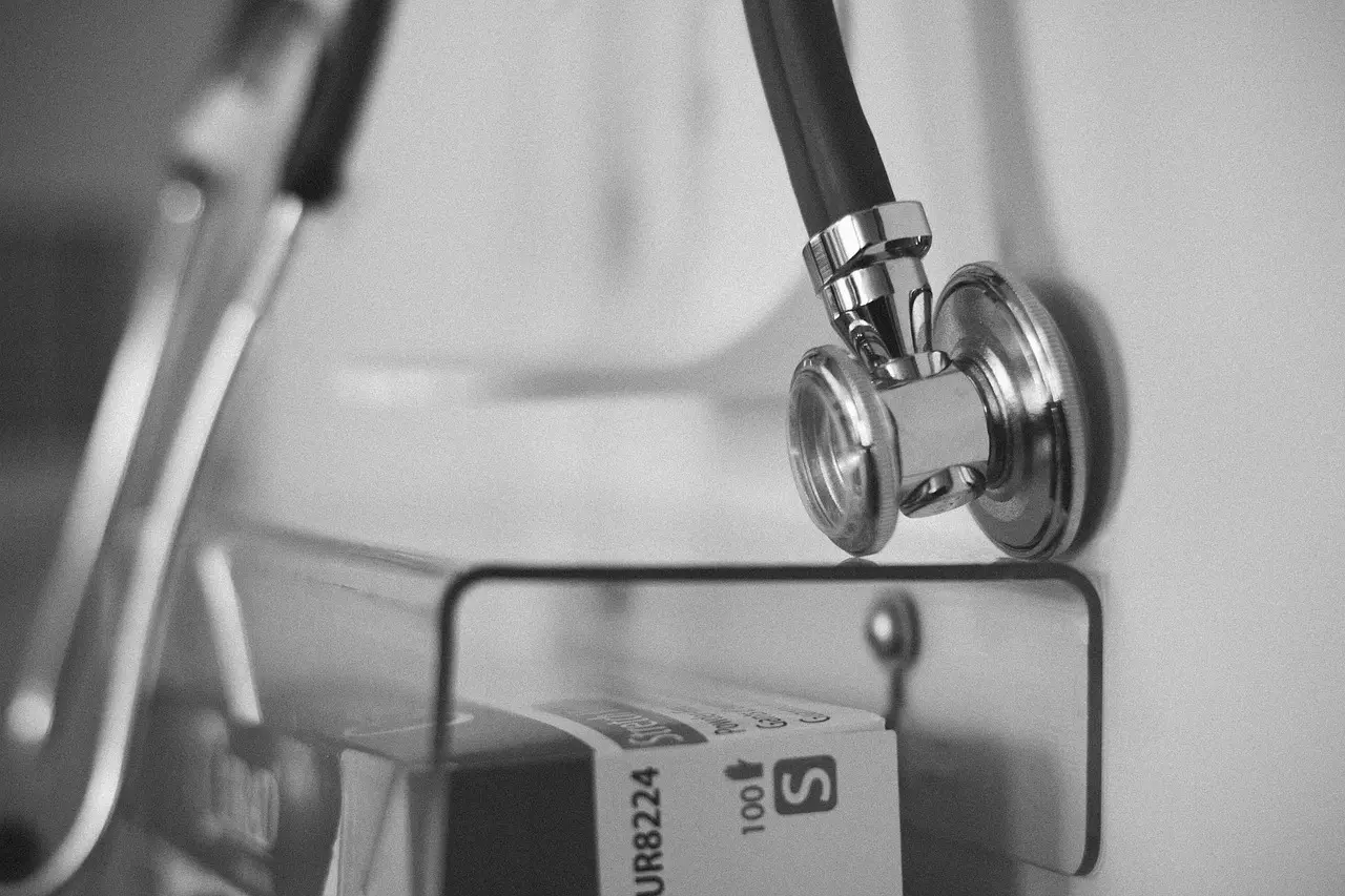 Stetoskop na stene vedľa lekárskeho vybavenia v ordinácii, zameranie na diagnostické nástroje.