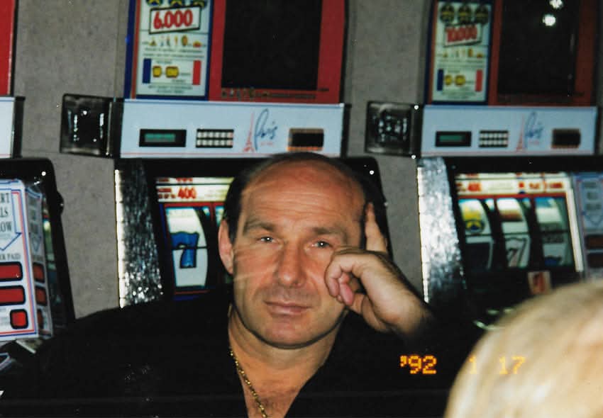 Andrzej Kolikowski pred hernými automatmi, rozmýšľajúci, foto z roku 1992.