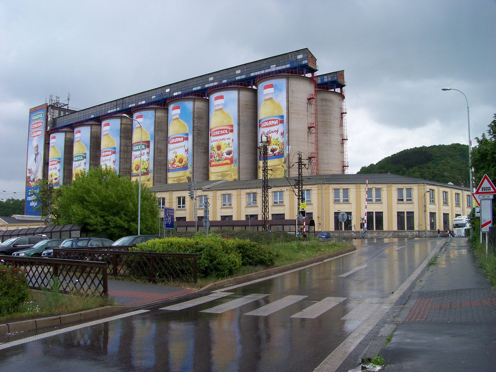 Priemyselná budova Setuza  s veľkorozmernými reklamami na rastlinný olej v zamračenom počasí.
