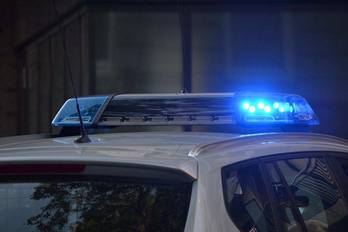 Policajné auto s modrým blikajúcim majákom, zobrazujúce bezpečnostnú pripravenosť.